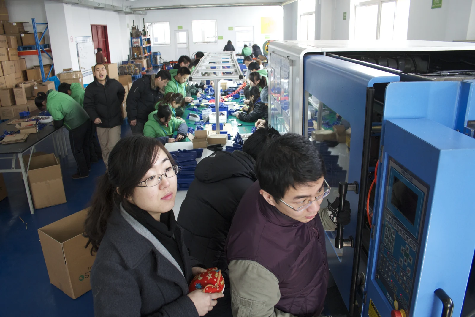 AquaStar team gathered around production equipment during a factory product launch