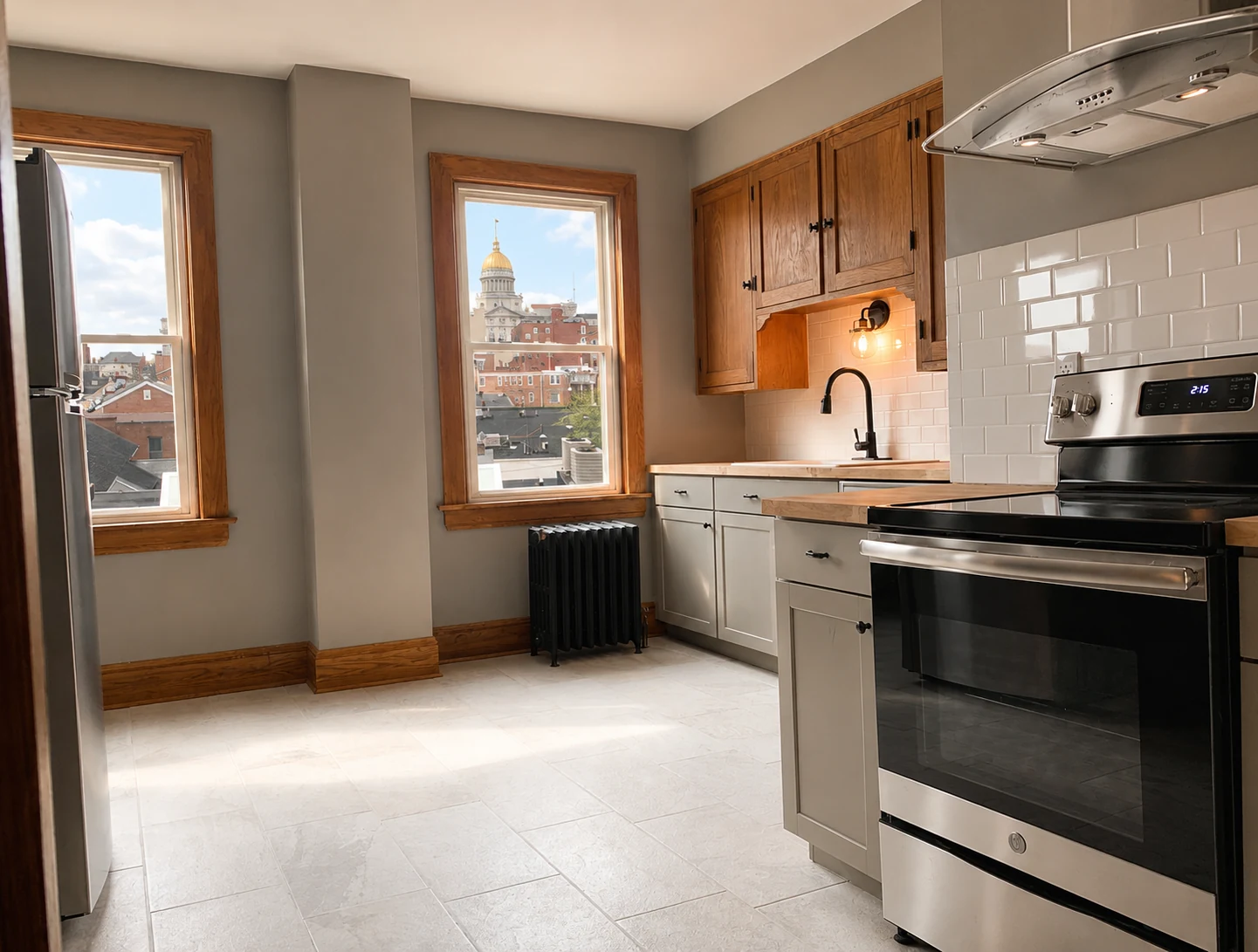 Renovated apartment kitchen at East Pittsburgh Street with wood cabinets and tall windows